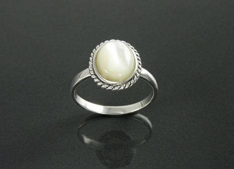 Une bague en argent 925 sertie d'une nacre ovale blanche sertie dans une bordure de style ancien en forme de corde. Un bijou artisanal en matière durable. Fait main localement à Paris par KRAMIKE, une petite boutique de confiance recommandée par ses milliers de clients.