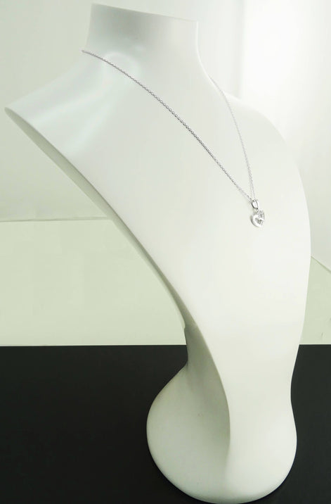 Un collier en chaîne argent avec un petit pendentif en forme de cœur ouvert.