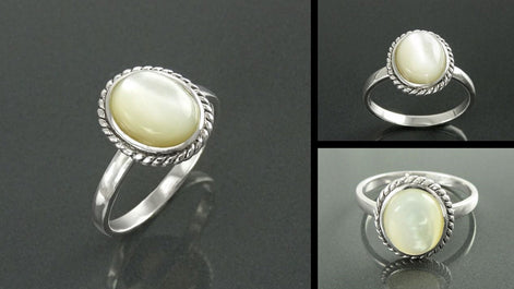 Une bague en argent avec une pierre ovale de nacre blanche sertie dans une bordure de style antique. Un bijou artisanal durable, fait main localement avec matières noble. KRAMIKE, une boutique de qualité (milliers d'avis positifs).
