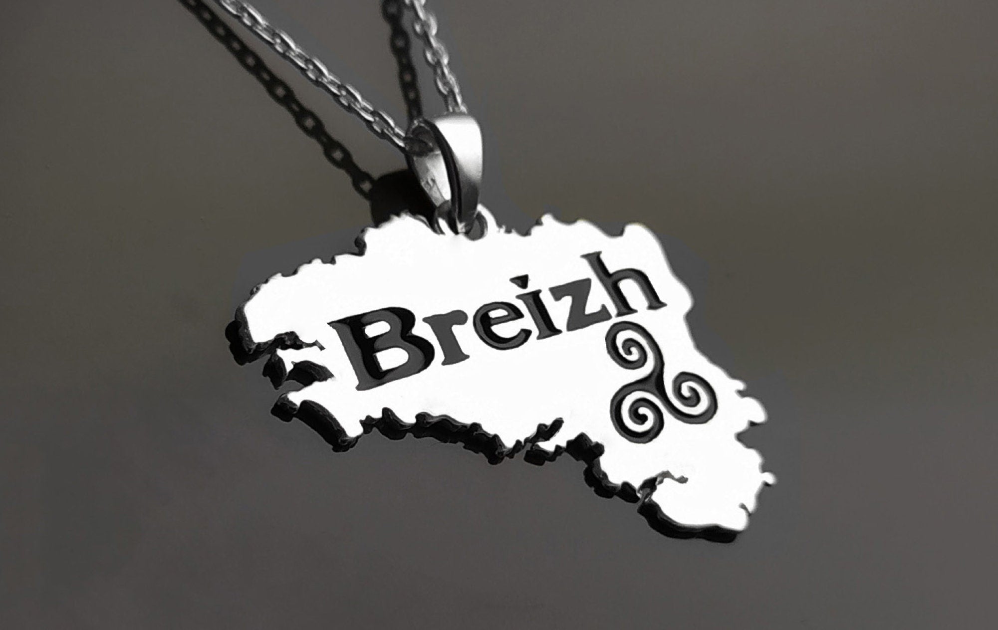Silver necklace with a pendant shaped like the region of Brittany, France. The pendant features the word "Breizh" and a Celtic knot design.

Brand: KRAMIKE
Type of jewelry: Pendant
Metal: 925 sterling silver
Size: 20×30 mm
Handmade: yes
Ships from: France
Necklace: chain on request

Brittany pendant, French regional gift, French Souvenir, Brittany gift, Breizh Necklace, Breizh pendant, Brittany jewelry, Bretagne pendant, Bretagne gift, French Brittany gift, Brittany necklace