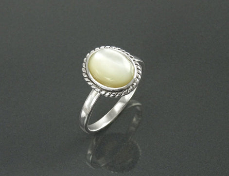 Une bague en argent 925 avec une pierre ovale blanche sertie dans une bordure en forme de corde. Un bijou artisanal durable. Fait à la main localement. Boutique de confiance recommandée par ses clients.