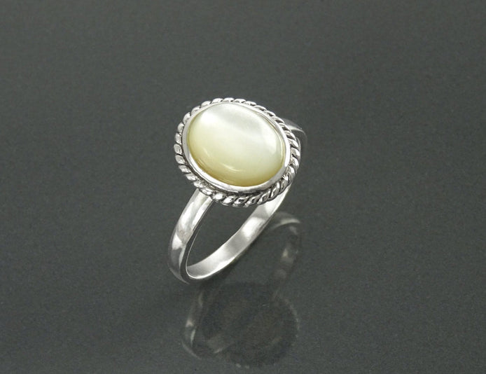 Une bague en argent 925 avec une pierre ovale blanche sertie dans une bordure en forme de corde. Un bijou artisanal durable. Fait à la main localement. Boutique de confiance recommandée par ses clients.