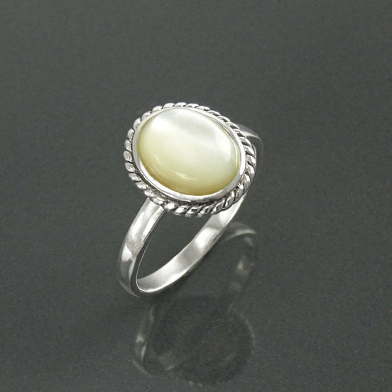 Une bague en argent 925 avec une pierre ovale blanche sertie dans une bordure en forme de corde. Un bijou artisanal durable. Fait à la main localement. Boutique de confiance recommandée par ses clients.