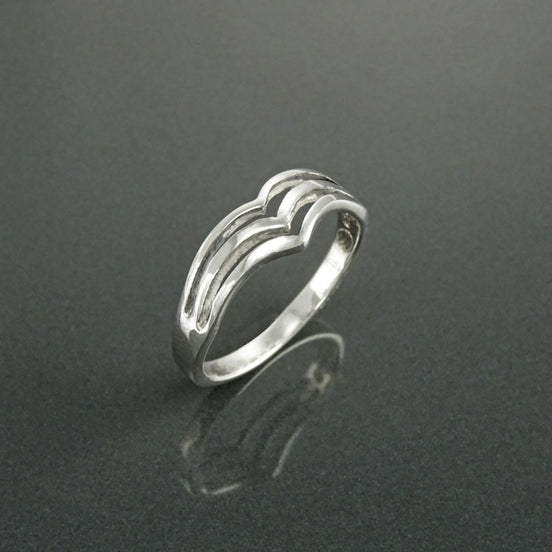 Une bague en argent massif avec un design unique composé de trois bandes superposées qui forment un cœur.