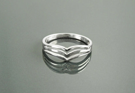 Une bague en argent 925 avec un motif triple chevron. La bague est en métal lisse et poli et a un style simple et moderne.