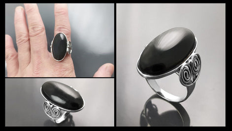 Scale on hand — ring shown for proportion — Sterling Silver ring with a large oval black onyx stone. The ring has a decorative spiral pattern on the side of the band.
• Metal: 925 sterling silver
• Stone: black onyx (cabochon)
• Stone size: 15×30 mm (approx.)
• Ring face: 15×30 mm | Band width: 3 mm
• Finish: high polish
• Handmade: yes | Country: FR
• Packaging: gift box | Resizing: on request