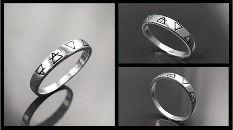 Une bague en argent avec quatre symboles gravés : un cercle avec une ligne qui le traverse, un triangle, un triangle inversé et un triangle avec une ligne qui le traverse.
VU DE Côté.
Bijou artisanal durable. Fait main local. Boutique de confiance recommandée.