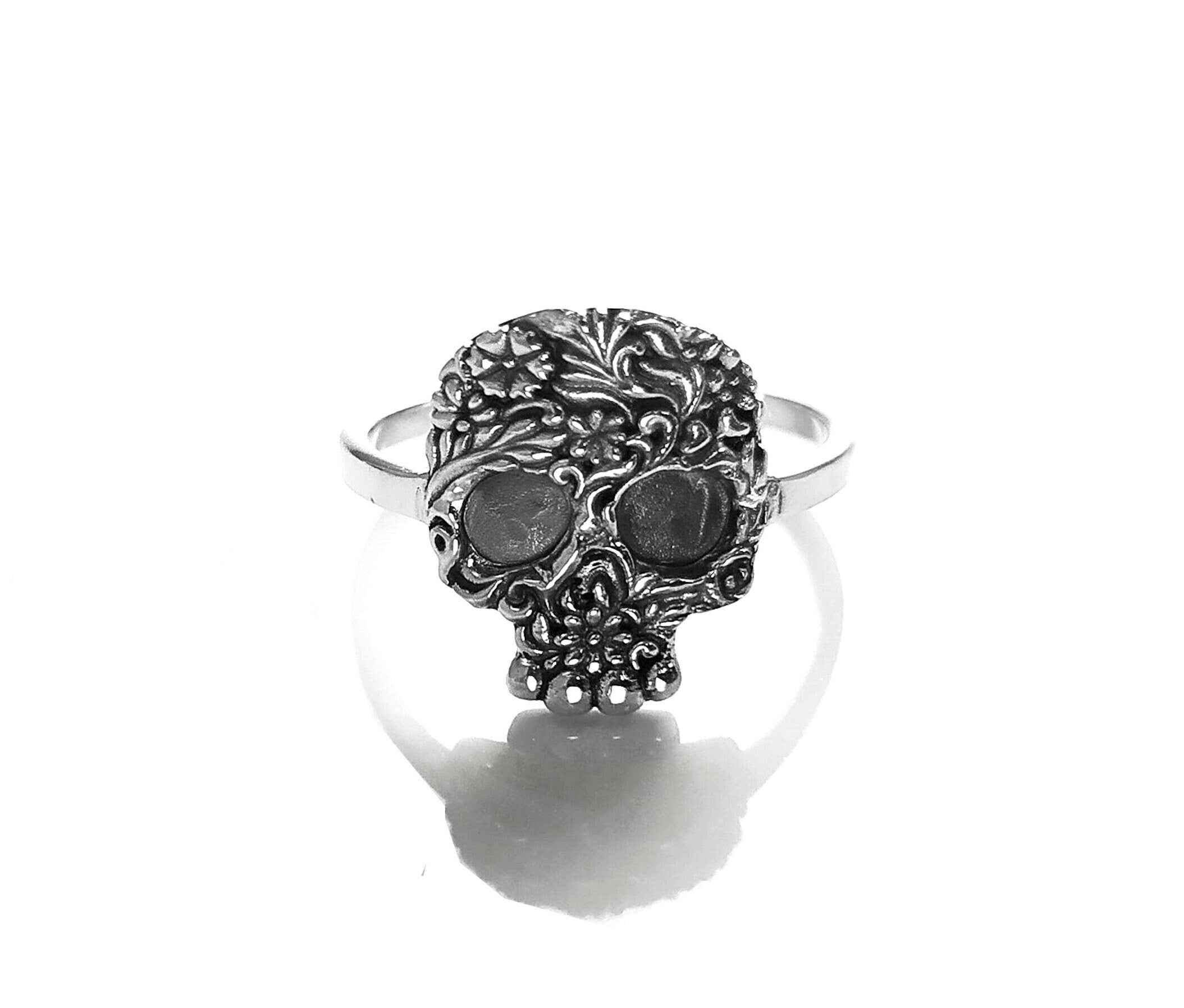 Bague en argent avec un motif de crâne détaillé. Le crâne est orné de motifs floraux complexes.