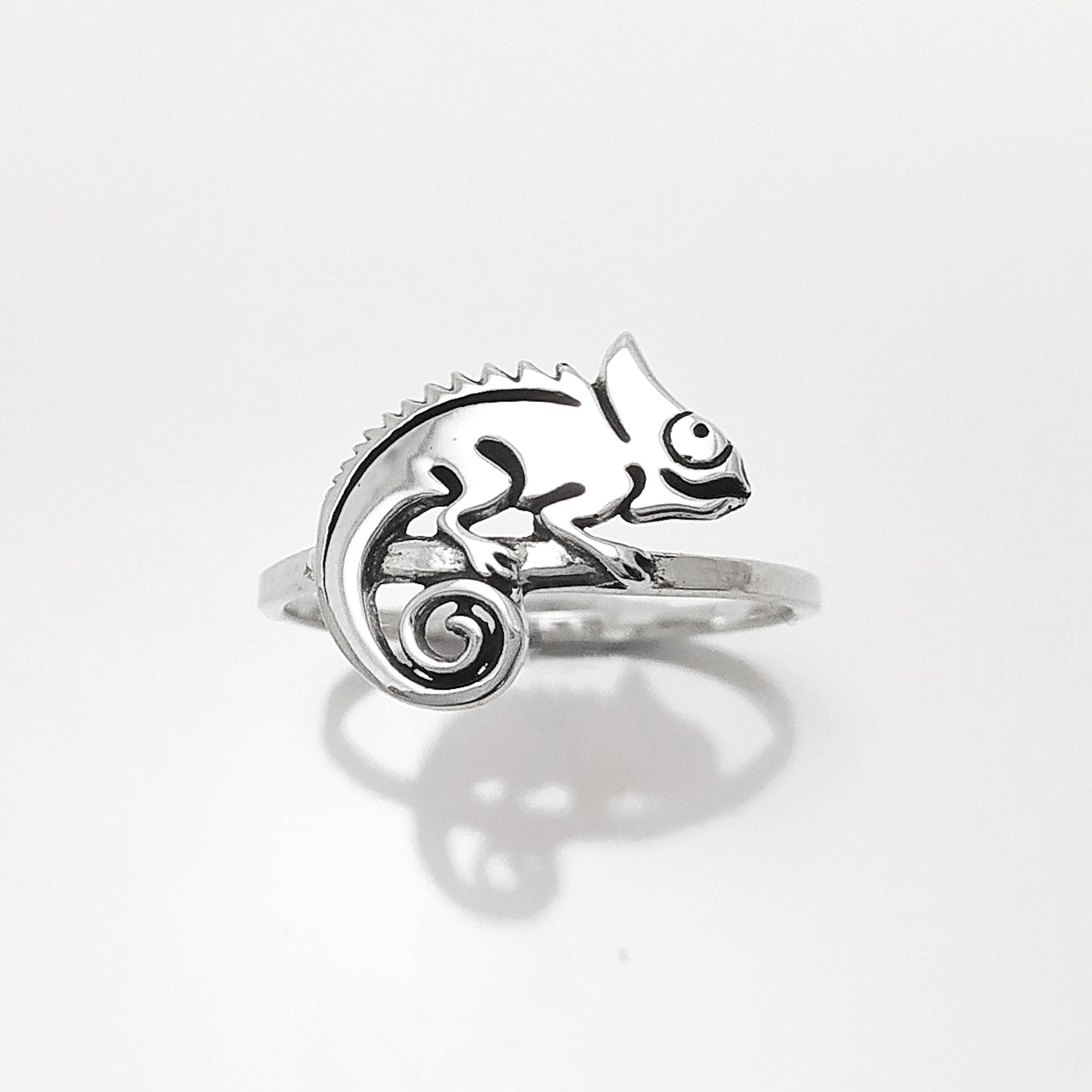 Une bague en argent avec un caméléon délicatement façonné sur le dessus. Le caméléon est sur un anneau en argent massif 925. Sa queue est enroulée.
Il est tout beau, et tranquillement posé. 

C'est une Bague parfaite pour un cadeau. Un bijou en argent 925 classique avec un motif fantaisiste.
Le meilleur du local : fait main, durable. Boutique fiable, milliers d'avis.