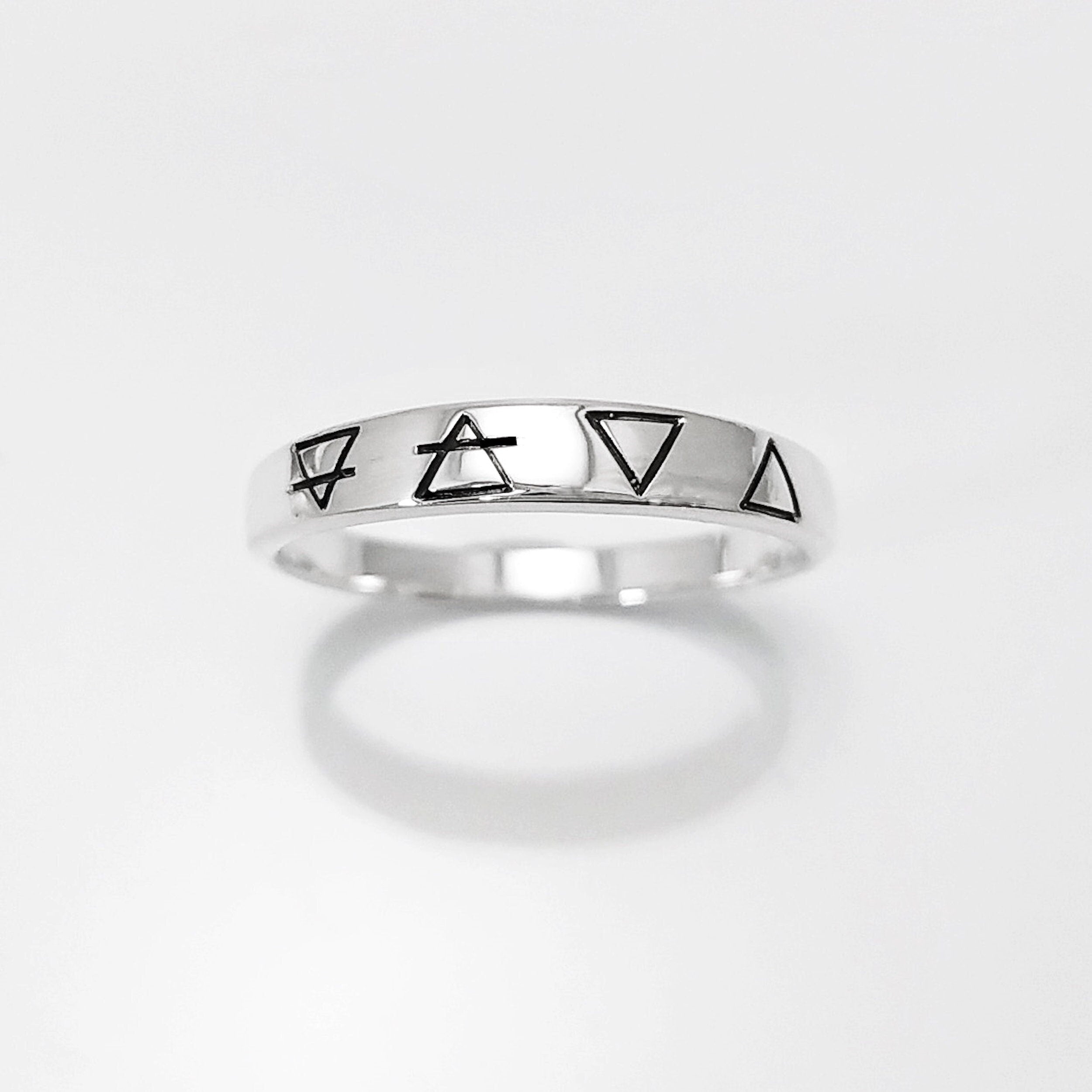 Une bague en argent avec quatre symboles gravés : un cercle avec une ligne qui le traverse, un triangle, un triangle inversé et un triangle avec une ligne qui le traverse.
Bague quatre éléments de la Planète Terre, argent 925, anneau des 4 élément symboles terrien : terre air eau feu, bijoux astrologie .
VU DE FACE.
Bijou artisanal durable. Fait main local. Boutique de confiance recommandée.