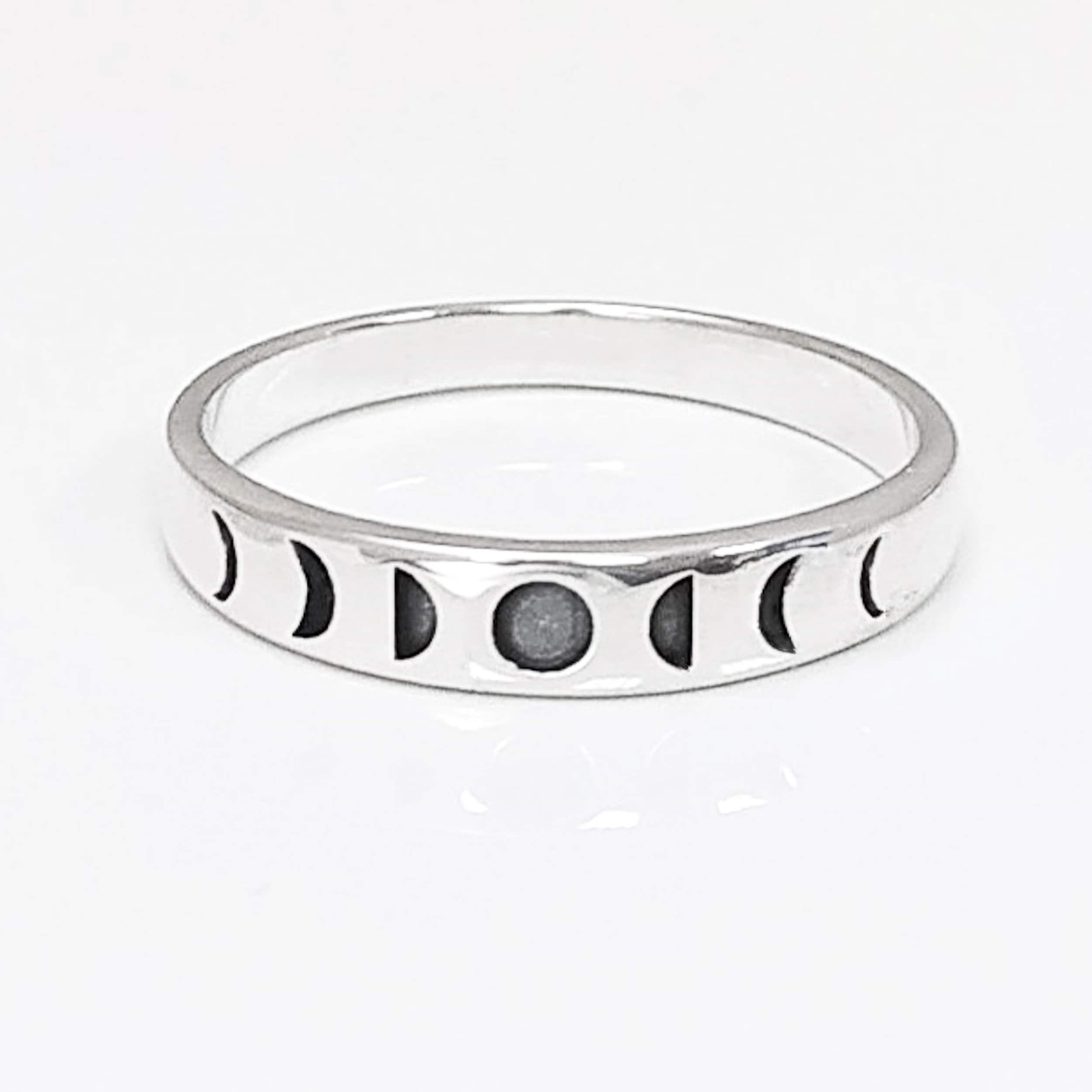 Une bague en argent avec un motif de phases lunaires. La bague présente une série de croissants de lune, chacun représentant une phase différente du cycle lunaire.
Un anneau fin et facile à porter, avec un design moderne.
Bague posée, vu de face. 
Durable, fait main, local. Créateurs sûrs. Boutique aux milliers d'avis.