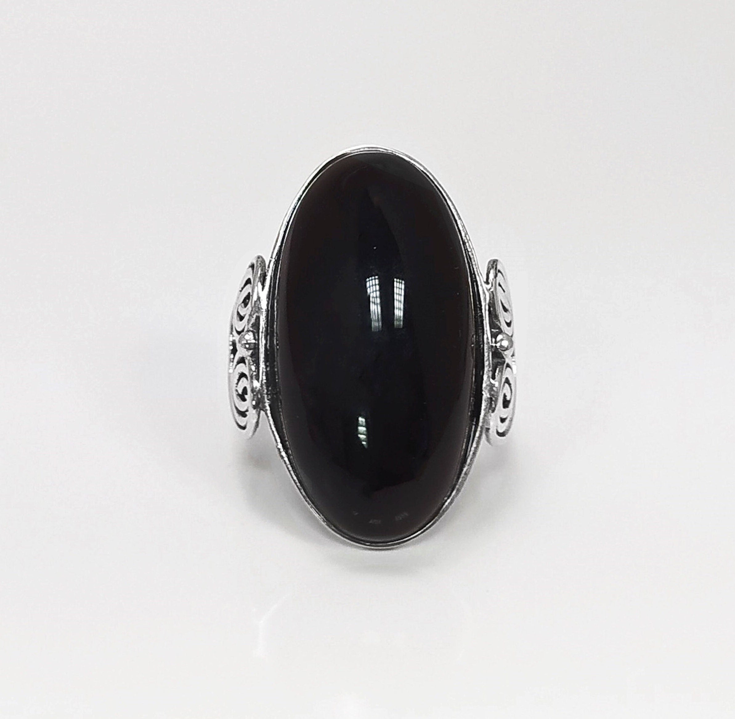 Close-up — glossy onyx stone and high-polish bezel setting.
• Metal: 925 sterling silver
• Stone: black onyx (cabochon)
• Stone size: 15×30 mm (approx.)
• Ring face: 15×30 mm | Band width: 3 mm
• Finish: high polish
• Handmade: yes | Country: FR
• Packaging: gift box | Resizing: on request
