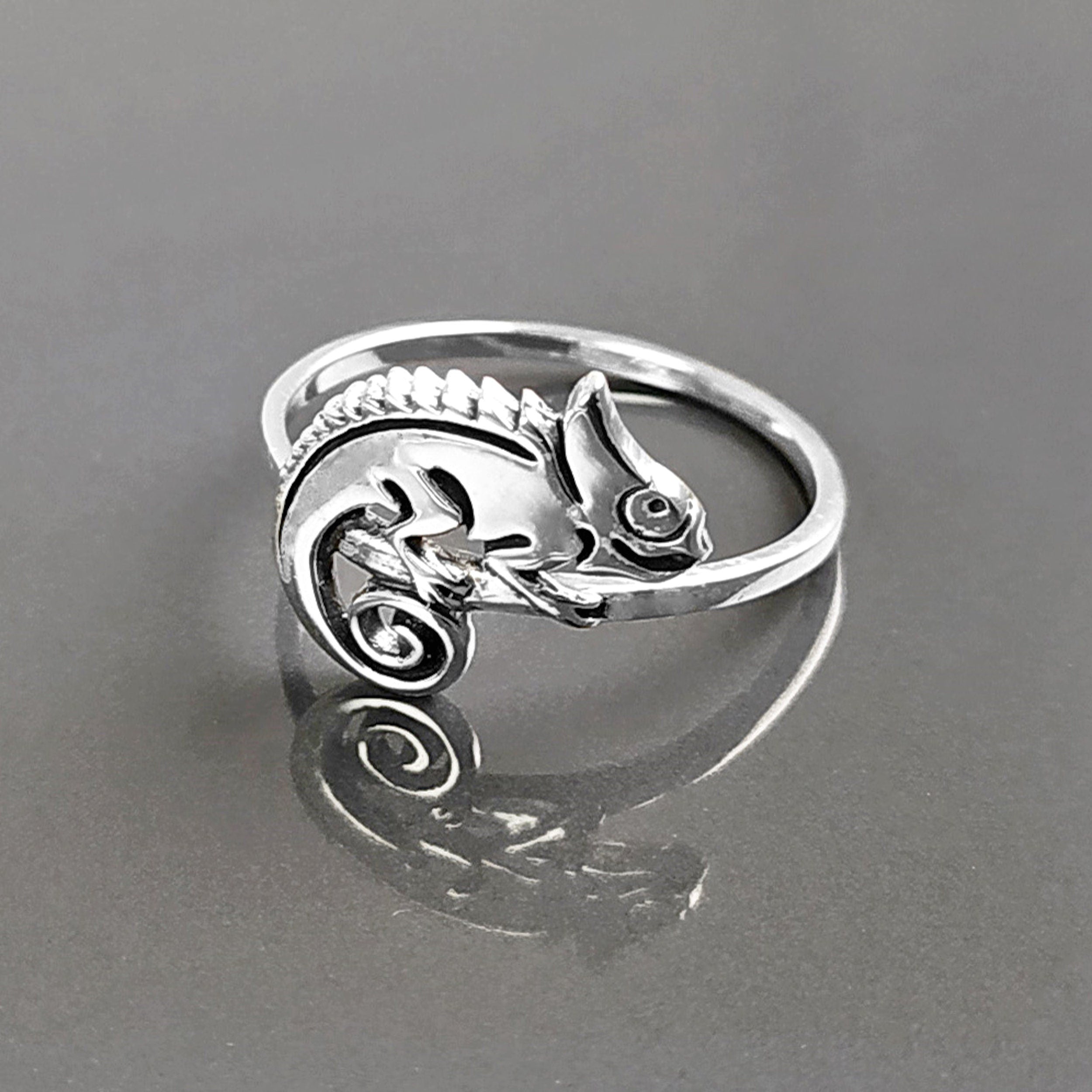 Une bague en argent avec un caméléon délicatement façonné sur le dessus. Le caméléon est sur un anneau en argent massif 925. Sa queue est enroulée.
Il est tout beau, et tranquillement posé. 

C'est une Bague parfaite pour un cadeau. Un bijou en argent 925 classique avec un motif fantaisiste.
Le meilleur du local : fait main, durable. Boutique fiable, milliers d'avis.