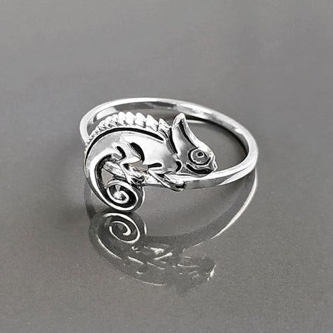 Une bague en argent avec un caméléon délicatement façonné sur le dessus. Le caméléon est sur un anneau en argent massif 925. Sa queue est enroulée.
Il est tout beau, et tranquillement posé. 

C'est une Bague parfaite pour un cadeau. Un bijou en argent 925 classique avec un motif fantaisiste.
Le meilleur du local : fait main, durable. Boutique fiable, milliers d'avis.
