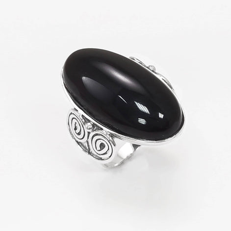 Top side view — Sterling Silver ring with a large oval black onyx stone. The ring has a decorative spiral pattern on the side of the band.
• Metal: 925 sterling silver
• Stone: black onyx (cabochon)
• Stone size: 15×30 mm (approx.)
• Ring face: 15×30 mm | Band width: 3 mm
• Finish: high polish
• Handmade: yes | Country: FR
• Packaging: gift box | Resizing: on request
