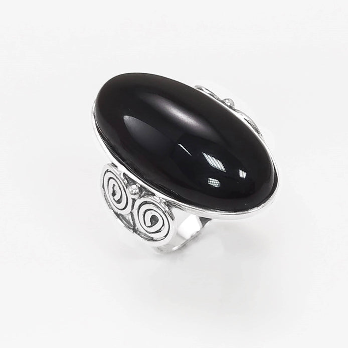 Top side view — Sterling Silver ring with a large oval black onyx stone. The ring has a decorative spiral pattern on the side of the band.
• Metal: 925 sterling silver
• Stone: black onyx (cabochon)
• Stone size: 15×30 mm (approx.)
• Ring face: 15×30 mm | Band width: 3 mm
• Finish: high polish
• Handmade: yes | Country: FR
• Packaging: gift box | Resizing: on request