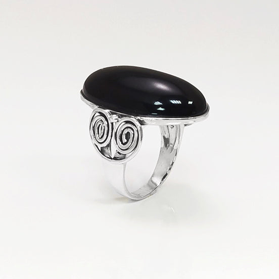 3/4 Side profile — Sterling Silver ring with a large oval black onyx cabochon stone. The ring has a vintage spiral pattern on the side of the band.
• Metal: 925 sterling silver
• Stone: black onyx (cabochon)
• Stone size: 15×30 mm (approx.)
• Ring face: 15×30 mm | Band width: 3 mm
• Finish: high polish
• Handmade: yes | Country: FR
• Packaging: gift box | Resizing: on request