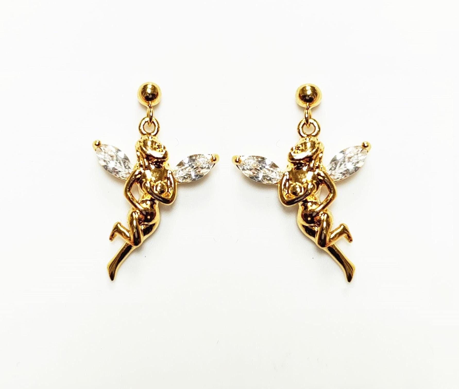 Une paire de boucles d'oreilles ange dorées. Chaque boucle d'oreille présente une figurine d'ange détaillée avec des ailes en cristal clair taillées en marquise. Les boucles d'oreilles ont une fermeture à tige et sont posées sur un fond blanc.