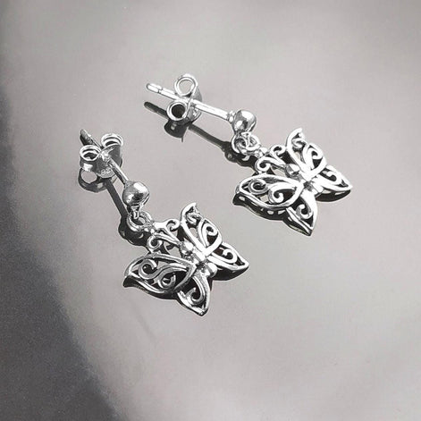 Une paire de boucles d'oreilles pendantes en argent en forme de papillon. Les boucles d'oreilles présentent un design délicat et complexe avec un motif de filigrane. 
Boucles d'oreilles papillon en Argent 925, Symbole de la Métamorphose, du renouvellement et du commencement d'un nouveau chapitre de vie.
Boucles vu de face. Des Papillons en filigrane sur tige.
Durable, fait main, local. Créateurs sûrs. Boutique aux milliers d'avis.