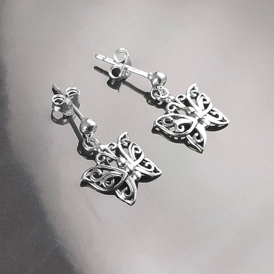 Une paire de boucles d'oreilles pendantes en argent en forme de papillon. Les boucles d'oreilles présentent un design délicat et complexe avec un motif de filigrane. 
Boucles d'oreilles papillon en Argent 925, Symbole de la Métamorphose, du renouvellement et du commencement d'un nouveau chapitre de vie.
Boucles vu de face. Des Papillons en filigrane sur tige.
Durable, fait main, local. Créateurs sûrs. Boutique aux milliers d'avis.