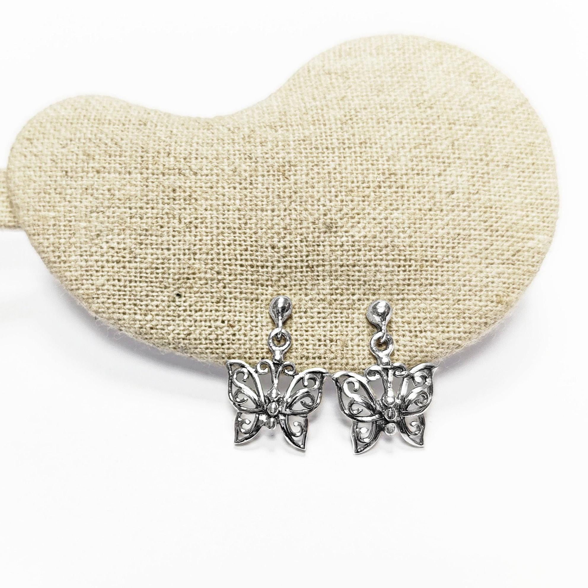 Une paire de boucles d'oreilles pendantes en argent en forme de papillon. Les boucles d'oreilles présentent un design délicat et complexe avec un motif de filigrane. 
Boucles d'oreilles papillon en Argent 925, Symbole de la Métamorphose, du renouvellement et du commencement d'un nouveau chapitre de vie.
Boucles vu de face. Des Papillons en filigrane sur tige.
Durable, fait main, local. Créateurs sûrs. Boutique aux milliers d'avis.