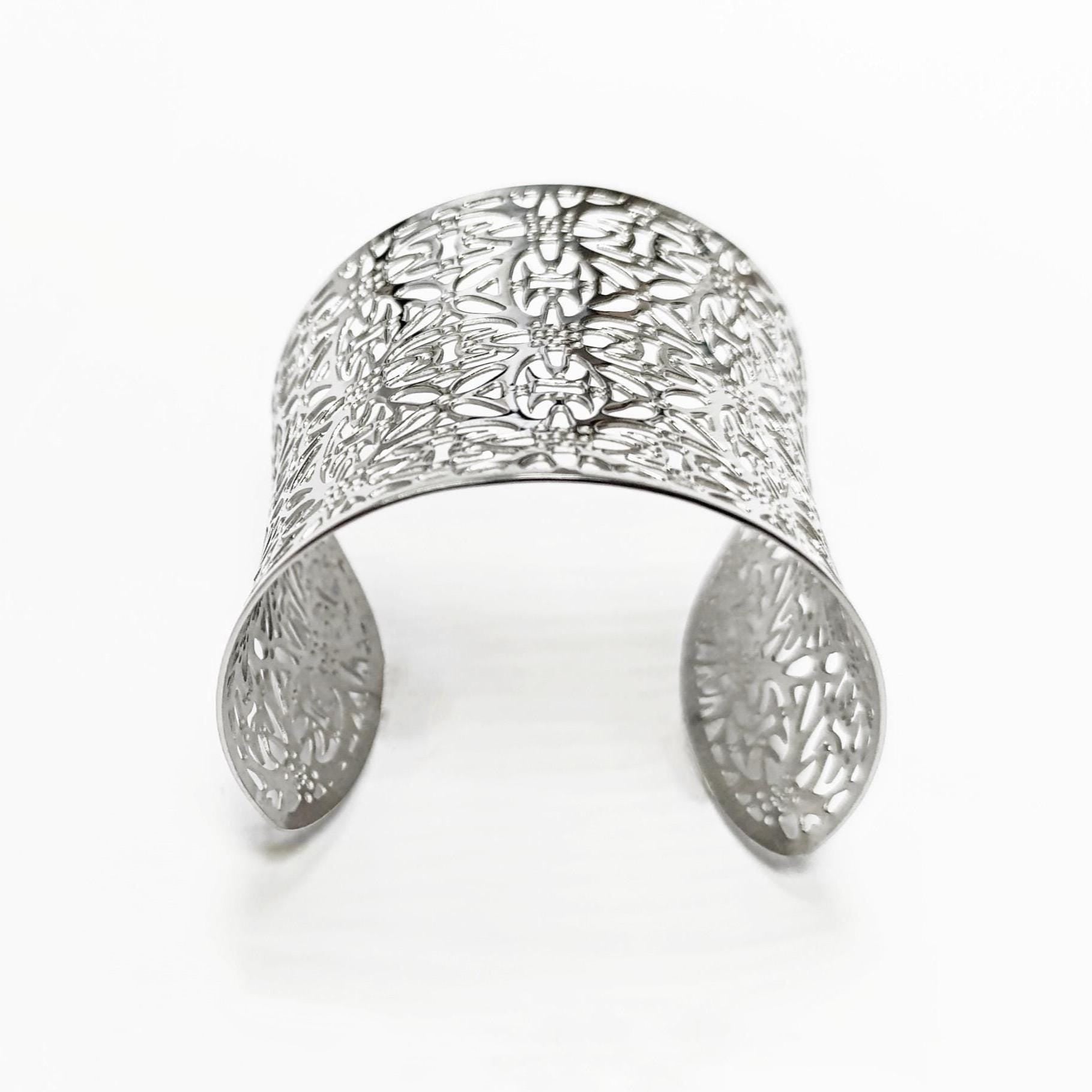 Fit detail — Easy to slip on Silver-toned cuff bracelet with an open design. The bracelet features a detailed floral pattern across the top and sides. The cuff is curved and open at the bottom, allowing for easy wear.

Brand: KRAMIKE
Type of jewelry: cuff / statement armor cuff
Metal: stainless steel
Color: silver-tone
Style: Filigree floral lace / modern boho
Diameter: 66 mm
Width: 60 mm
Ships from: France