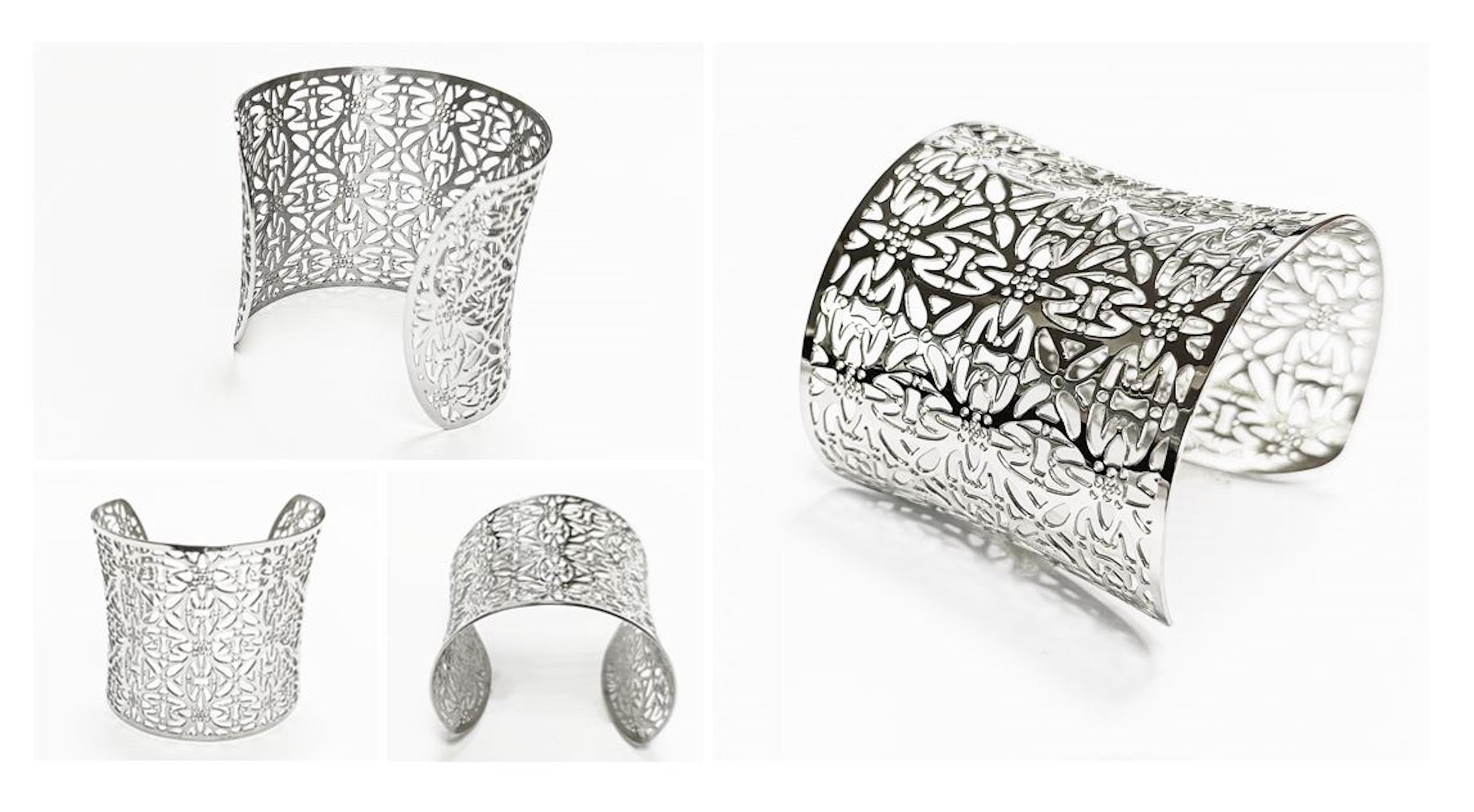Multiple views — A silver-colored cuff bracelet with an openwork floral design. The wide bracelet curves to fit the wrist and features a repeating pattern of stylized flowers and leaves. The metal has a polished finish.

Brand: KRAMIKE
Type of jewelry: cuff / statement armor cuff
Metal: stainless steel
Color: silver-tone
Style: Filigree floral lace / modern boho • cuff
Diameter: 66 mm
Width: 60 mm
Ships from: France