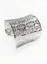 Angle view — Silver cuff bracelet with a floral pattern. The wide bracelet has a curved shape and is made of a shiny, reflective metal. The openwork design allows light to pass through, creating a delicate and intricate look.

Brand: KRAMIKE
Type of jewelry: cuff / statement armor cuff
Metal: stainless steel
Color: silver-tone
Style: Filigree floral lace / modern boho
Diameter: 66 mm
Width: 60 mm
Ships from: France