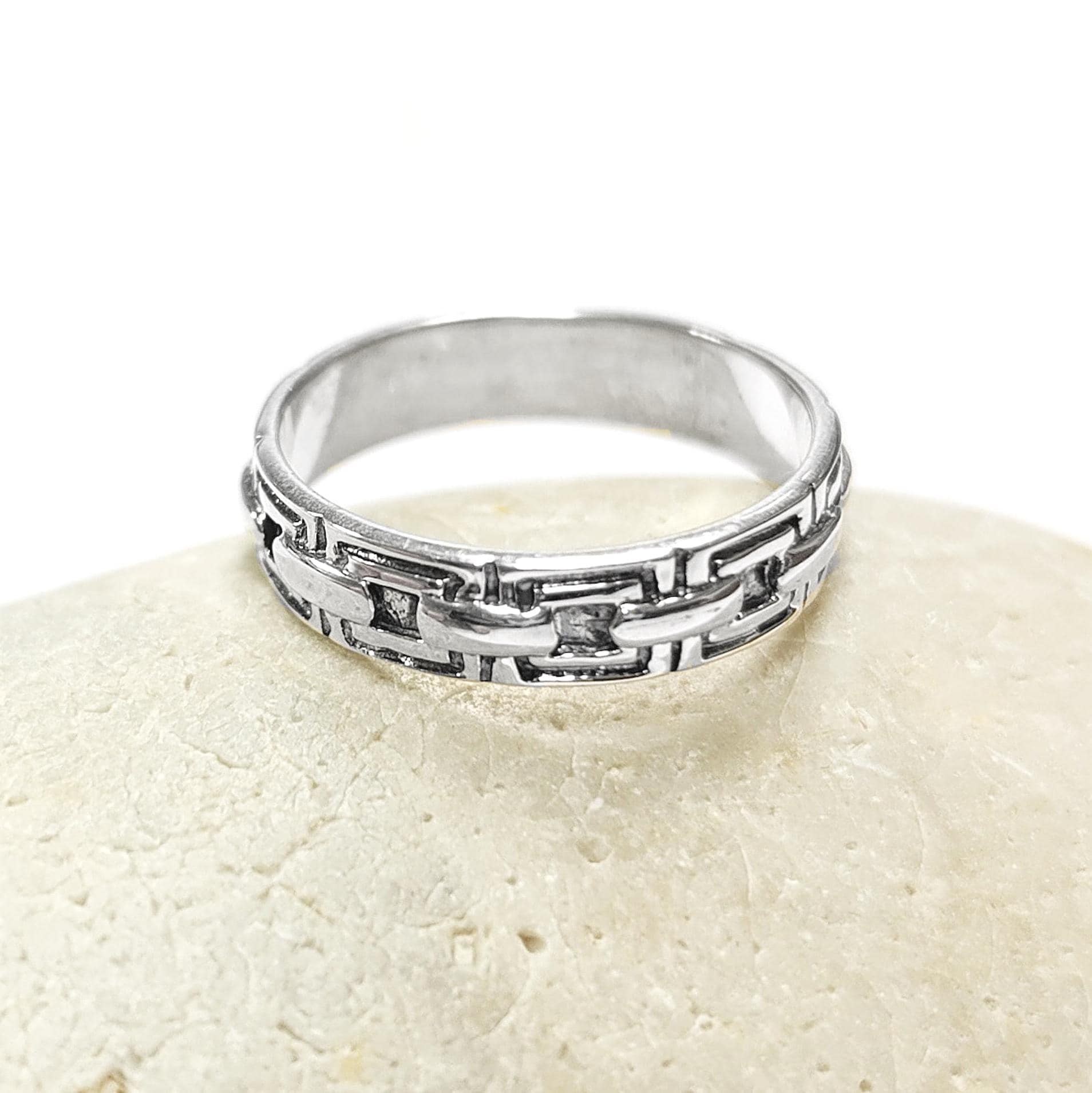 Une bague en argent massif 925 avec un motif Chaînage.
La bague présente un motif détaillé de chaînes entrelacés, créant une surface texturée. Plusieurs vues mettent en valeur le savoir-faire et le design complexe de la bague.
Vu bague posée sur une pierre.
Artisanat durable local. Fait main. Boutique de confiance aux milliers de ventes.