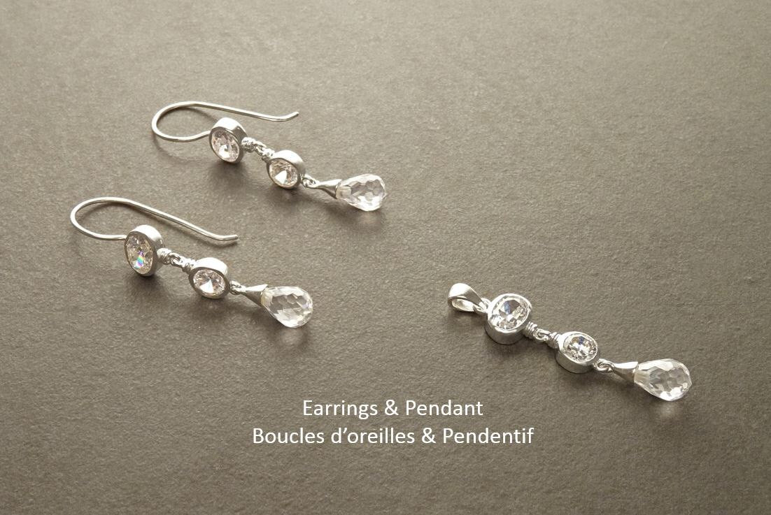 Une paire de boucles d'oreilles et un pendentif en argent avec des gouttes de cristal clair. Les boucles d'oreilles et le pendentif comportent chacun trois pierres de cristal.