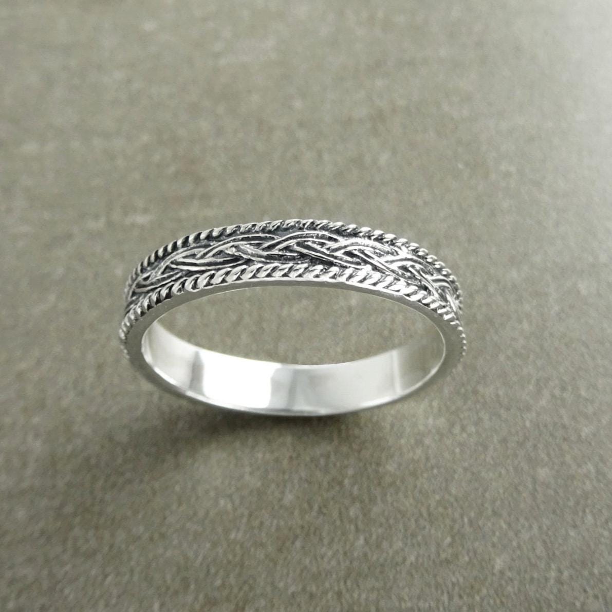 Une bague en argent massif 925 avec un motif tressé. 
La bague présente un motif détaillé de brins entrelacés, créant une surface texturée. Plusieurs vues mettent en valeur le savoir-faire et le design complexe de la bague.
Vu d'en bas.
Bijou artisanal durable. Fait main local. Boutique de confiance recommandée.
