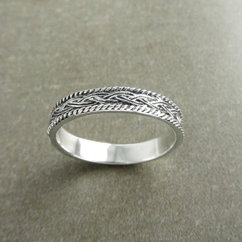 Une bague en argent massif 925 avec un motif tressé. 
La bague présente un motif détaillé de brins entrelacés, créant une surface texturée. Plusieurs vues mettent en valeur le savoir-faire et le design complexe de la bague.
Vu d'en bas.
Bijou artisanal durable. Fait main local. Boutique de confiance recommandée.