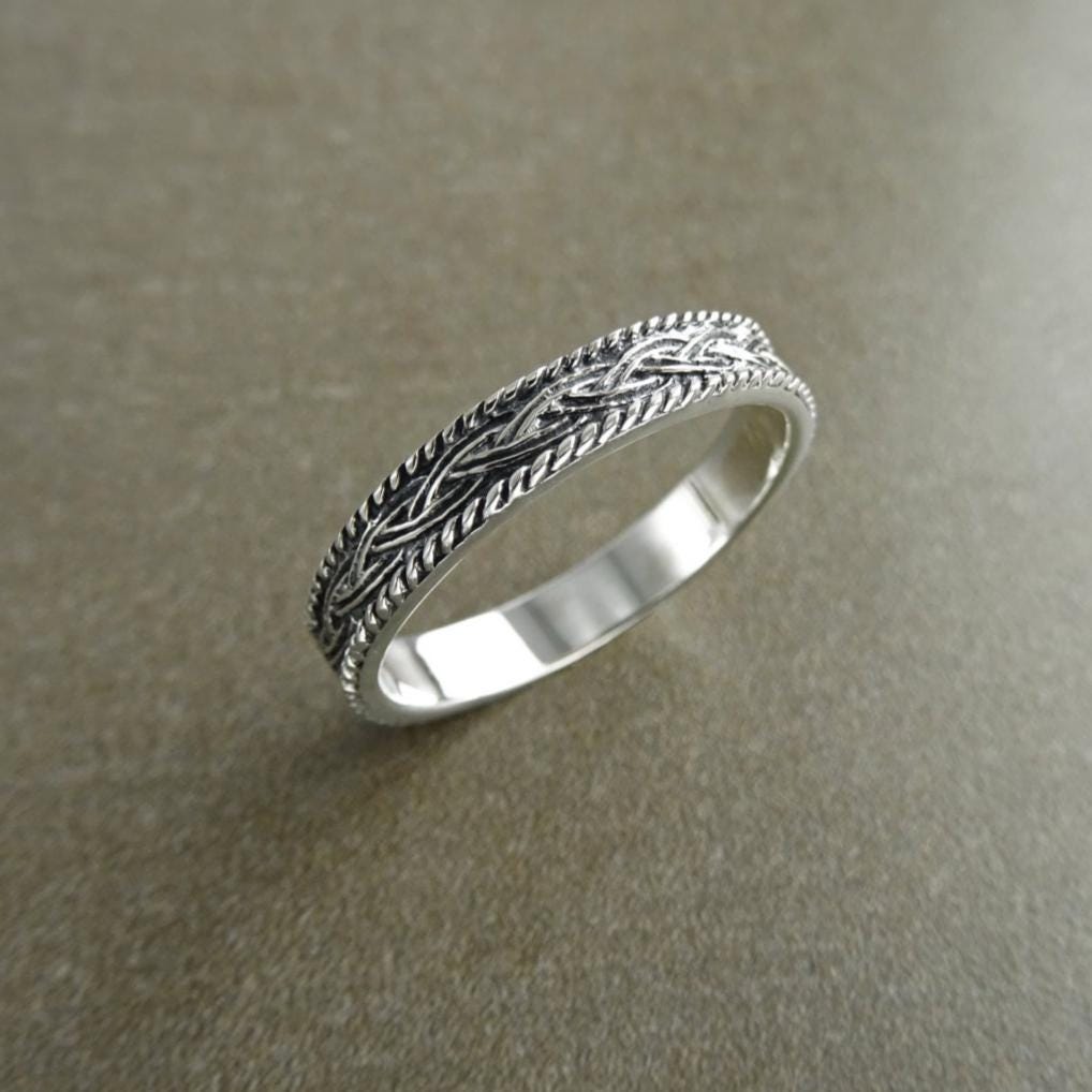 Une bague en argent massif 925 avec un motif tressé. 
La bague présente un motif détaillé de brins entrelacés, créant une surface texturée. Plusieurs vues mettent en valeur le savoir-faire et le design complexe de la bague.
Vu bague sur le côté.
KRAMIKE est une marque de Bijoux de très bonne qualité avec un service clients au TOP.
Bijou artisanal durable. Fait main local. Boutique de confiance recommandée 5 étoiles.