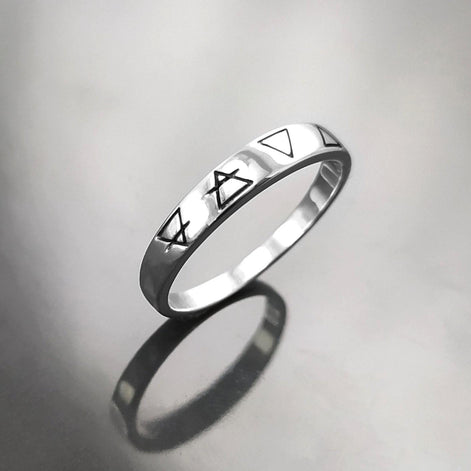 Une bague en argent avec quatre symboles gravés : un cercle avec une ligne qui le traverse, un triangle, un triangle inversé et un triangle avec une ligne qui le traverse.
Bague quatre éléments de la Planète Terre, argent 925, anneau des 4 élément symboles terrien : terre air eau feu, bijoux astrologie.
VU DE Côté.
Bijou artisanal durable. Fait main local. Boutique de confiance recommandée.