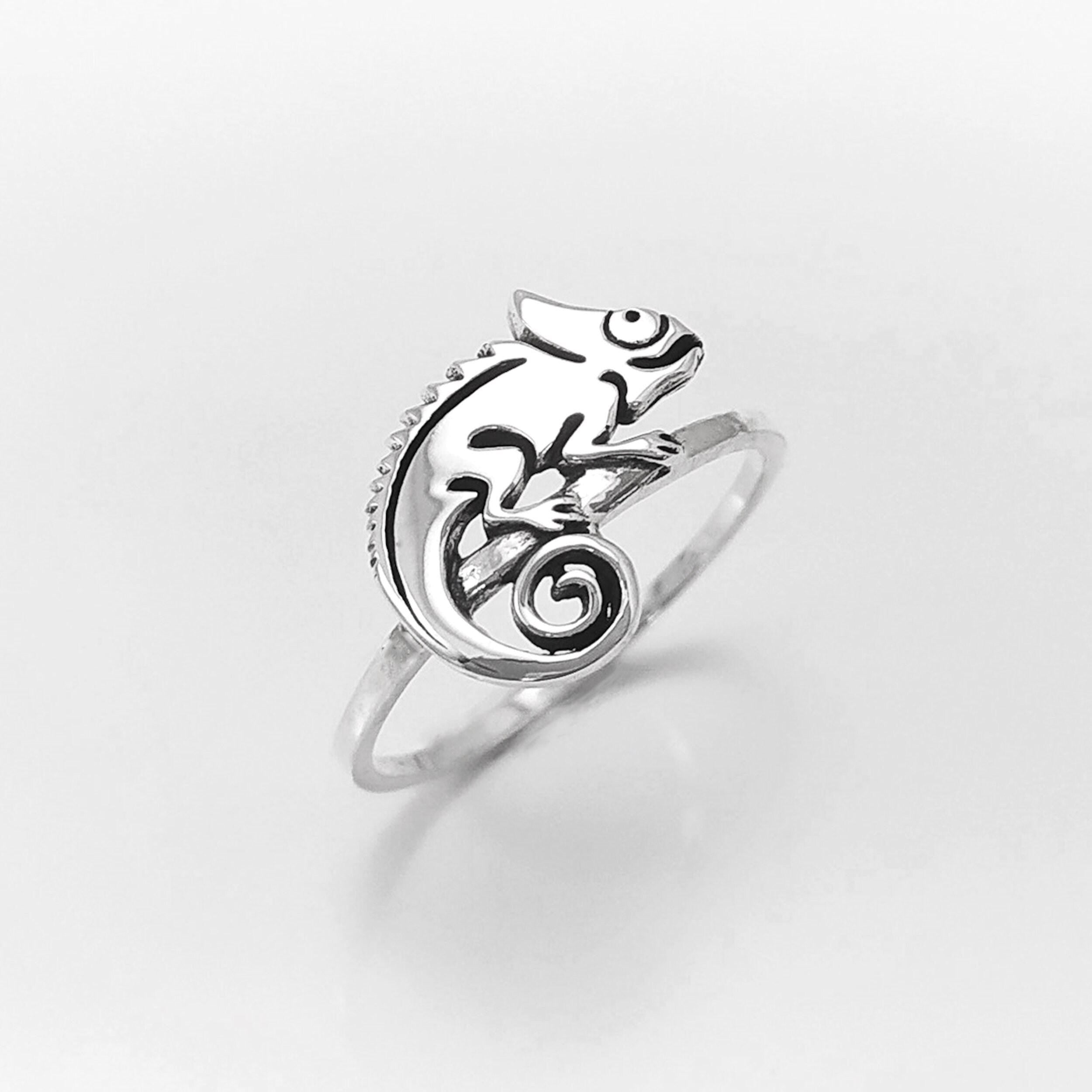 Une bague en argent avec un caméléon délicatement façonné sur le dessus. Le caméléon est sur un anneau en argent massif 925. Sa queue est enroulée.
Il est tout beau, et tranquillement posé. 

C'est une Bague parfaite pour un cadeau. Un bijou en argent 925 classique avec un motif fantaisiste.
Le meilleur du local : fait main, durable. Boutique fiable, milliers d'avis.