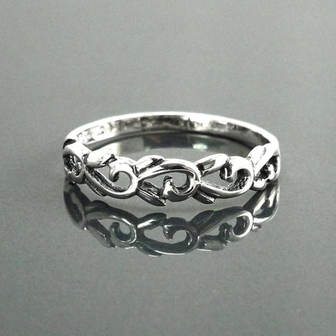 Une bague en argent massif 925 avec un anneau fin et arrondi avec un motif incurvé en relief sur la face. La bague a une finition polie, reflétant la lumière. La bague est un anneau à motif filigrané. Vu de face.
Qualité artisanale sûre. Local. Durable. Boutique de confiance recommandée.