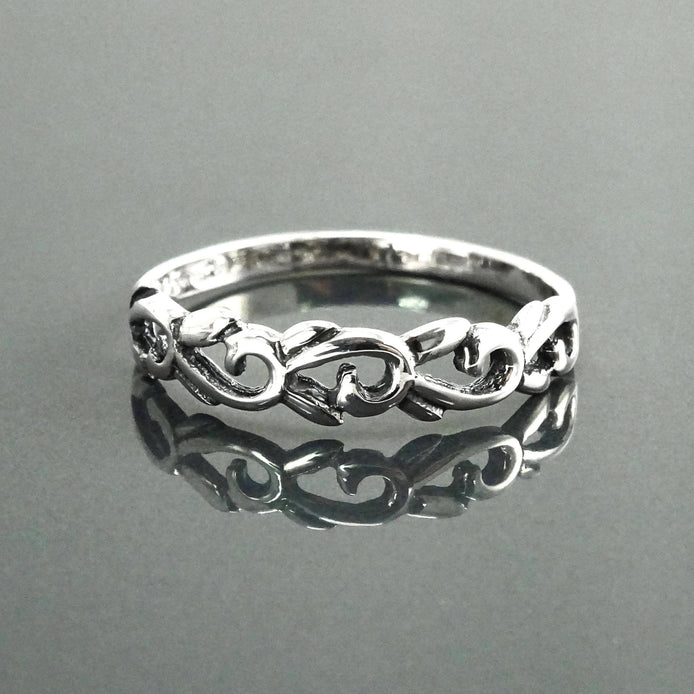 Une bague en argent massif 925 avec un anneau fin et arrondi avec un motif incurvé en relief sur la face. La bague a une finition polie, reflétant la lumière. La bague est un anneau à motif filigrané. Vu de face.
Qualité artisanale sûre. Local. Durable. Boutique de confiance recommandée.