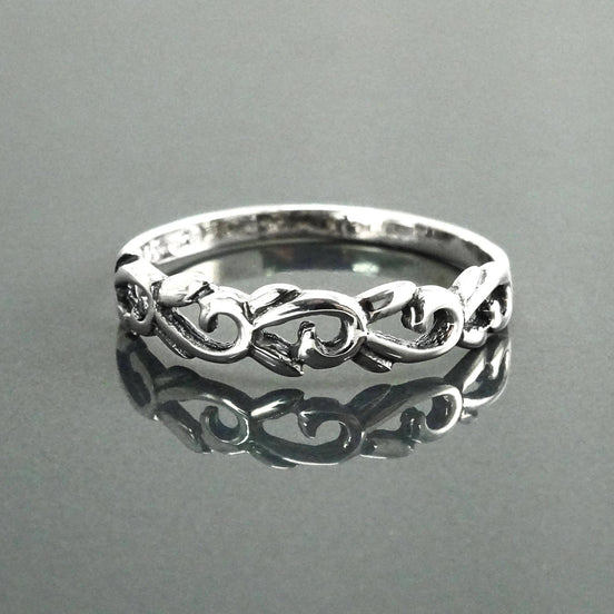 Une bague en argent massif 925 avec un anneau fin et arrondi avec un motif incurvé en relief sur la face. La bague a une finition polie, reflétant la lumière. La bague est un anneau à motif filigrané. Vu de face.
Qualité artisanale sûre. Local. Durable. Boutique de confiance recommandée.