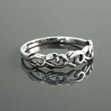 Une bague en argent massif 925 avec un anneau fin et arrondi avec un motif incurvé en relief sur la face. La bague a une finition polie, reflétant la lumière. La bague est un anneau à motif filigrané. Vu sur le côté.
Qualité artisanale sûre. Local. Durable. Boutique de confiance recommandée.
