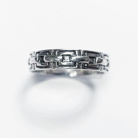 Une bague en argent massif 925 avec un motif Chaînage.
La bague présente un motif détaillé de chaînes entrelacés, créant une surface texturée. Plusieurs vues mettent en valeur le savoir-faire et le design complexe de la bague.
Vu bague de face.
Artisanat durable local. Fait main. Boutique de confiance aux milliers de ventes.