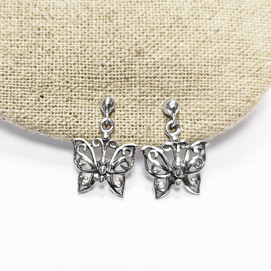 Une paire de boucles d'oreilles pendantes en argent en forme de papillon. Les boucles d'oreilles présentent un design délicat et complexe avec un motif de filigrane. 
Boucles d'oreilles papillon en Argent 925, Symbole de la Métamorphose, du renouvellement et du commencement d'un nouveau chapitre de vie.
Boucles vu de face. Des Papillons en filigrane sur tige.
Durable, fait main, local. Créateurs sûrs. Boutique aux milliers d'avis.