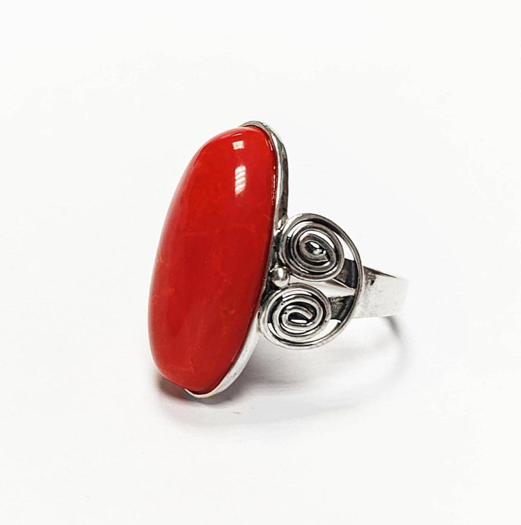 Bague en argent ornée d'une grosse pierre rouge vif de forme ovale. 
Le sertissage de la bague est en argent massif 925, avec un motif tourbillonnant décoratif sur le côté. 
La pierre centrale est poli avec un rouge vif.
La bague est facile à porter, et se marie très bien avec les vêtements au quotidien. Vu sur le côté.
Le meilleur du local : fait main, durable. Boutique fiable, milliers d'avis.
KRAMIKE est une marque de Bijoux de très bonne qualité avec un service clients au TOP.