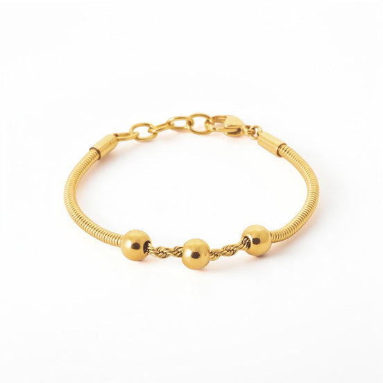 A Minimalist 18K Gold Filled Snake Chain with Triple Bead, lay on neutral background.
Product type: bracelet
Material: 18K gold filled, stainless steel
Length : adjustable 18-20cm
Width : 3mm
Clasp : lobster clasp
Color: yellow gold
Style: minimalist, dainty, elegant
Design details: snake chain, three polished beads, twisted connector detail
Best for: everyday wear, layering, gifting, minimalist jewelry lovers