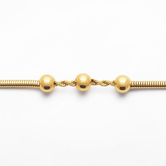 Focus on a Minimalist 18K Gold Filled Snake Chain with Triple Bead.

Product type: bracelet
Material: 18K gold filled, stainless steel
Length : adjustable 18-20cm
Width : 3mm
Clasp : lobster clasp
Color: yellow gold
Style: minimalist, dainty, elegant
Design details: snake chain, three polished beads, twisted connector detail
Best for: everyday wear, layering, gifting, minimalist jewelry lovers