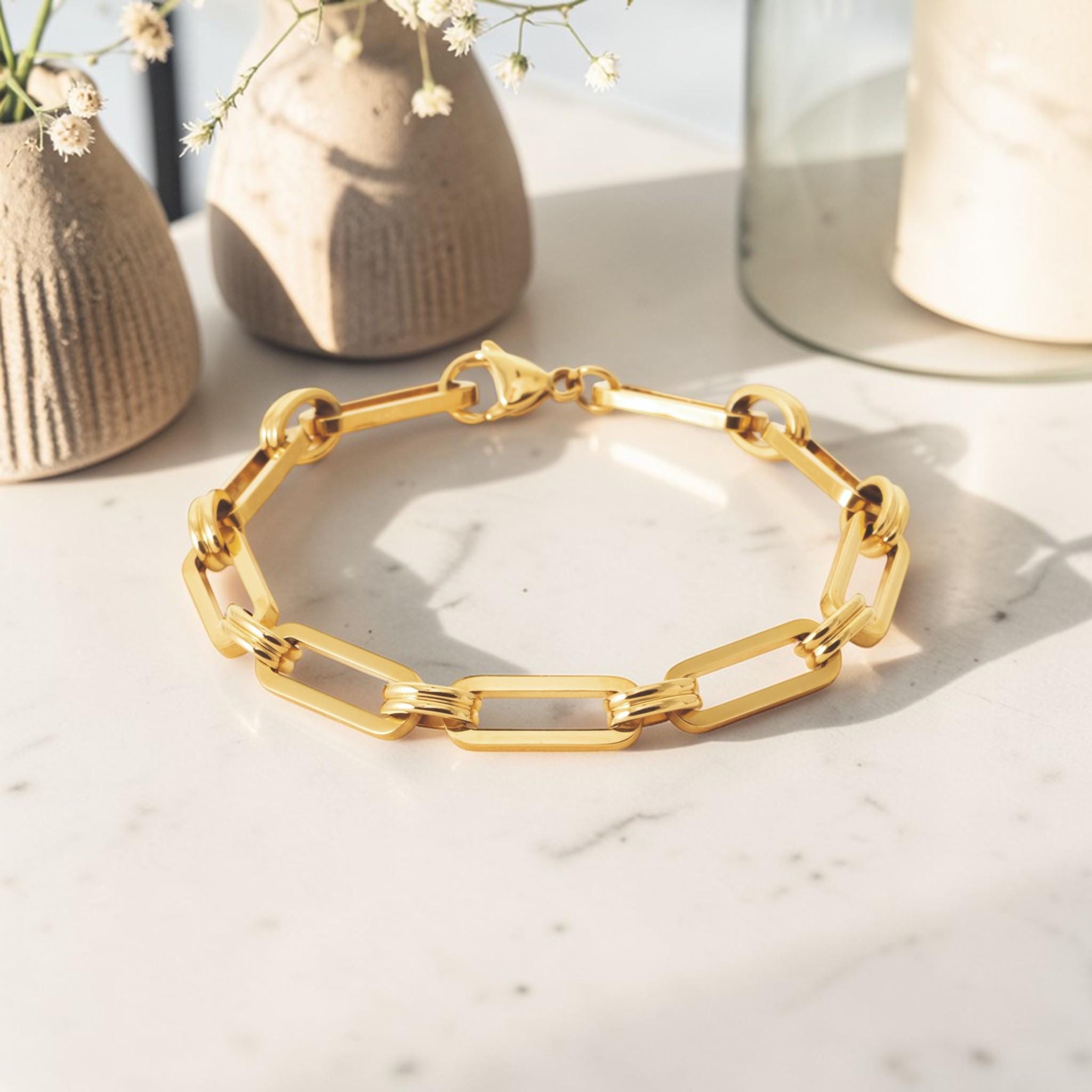 A 18K Gold Filled Paperclip Bracelet lay on a marble table.
Product type: bracelet
Material:  18K Gold Filled, stainless steel base
Color: yellow gold
Style: minimalist, modern, elegant
Design details: elongated rectangular paperclip links, polished finish, geometric chain design, lobster clasp
Best for: everyday wear, layering, gifting, minimalist jewelry lovers, modern capsule wardrobes