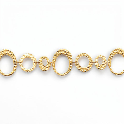 focus view of a geometric bracelet 
Product type: bracelet
Material:  18K Gold Filled, stainless steel base
Color: yellow gold
Style: statement, geometric, elegant, modern
Design details: hammered open circle and oval links, graduated sizes, textured finish, airy openwork design, lobster clasp with extender
Best for: statement styling, special occasions, everyday elevated wear, gifting, artistic jewelry lovers