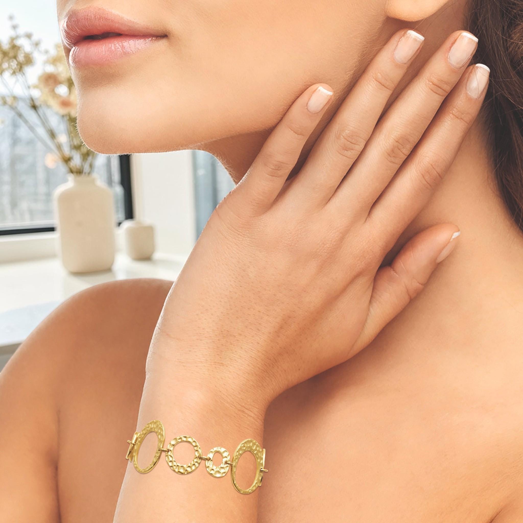 view of a geometric bracelet worn by a woman hand
Product type: bracelet
Material:  18K Gold Filled, stainless steel base
Color: yellow gold
Style: statement, geometric, elegant, modern
Design details: hammered open circle and oval links, graduated sizes, textured finish, airy openwork design, lobster clasp with extender
Best for: statement styling, special occasions, everyday elevated wear, gifting, artistic jewelry lovers