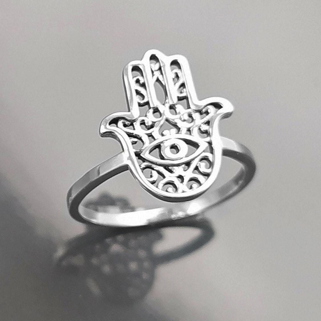 Product type: ring
Material: sterling silver
Color: silver
Style: spiritual, symbolic, boho, delicate
Design details: Hamsa hand motif, centered evil eye symbol, openwork detailing, slim sterling silver band, minimalist everyday silhouette
Best for: everyday wear, symbolic jewelry lovers, spiritual gifting, protection-themed jewelry, stacking, birthdays, anniversaries, Mother’s Day