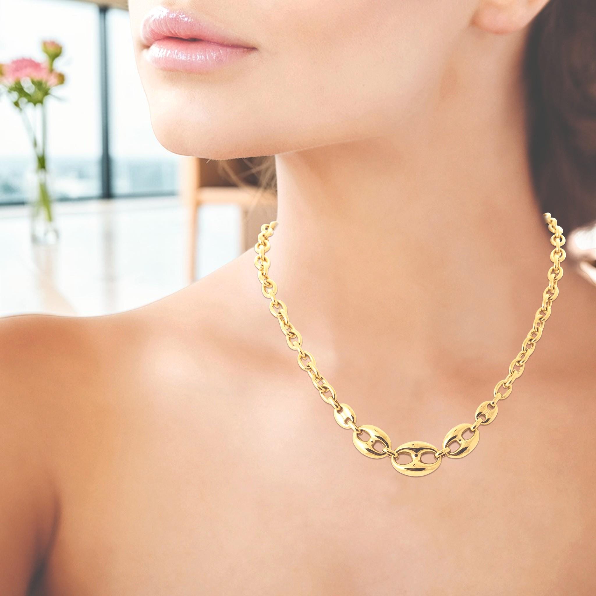 A 18K Gold Filled coffee bean link necklace with polished oval centerpiece links and a modern rounded chain design. Elegant, minimalist, and slightly bold, it is ideal for everyday wear, layering, and gifting. Here a view of the necklace worn by a woman.