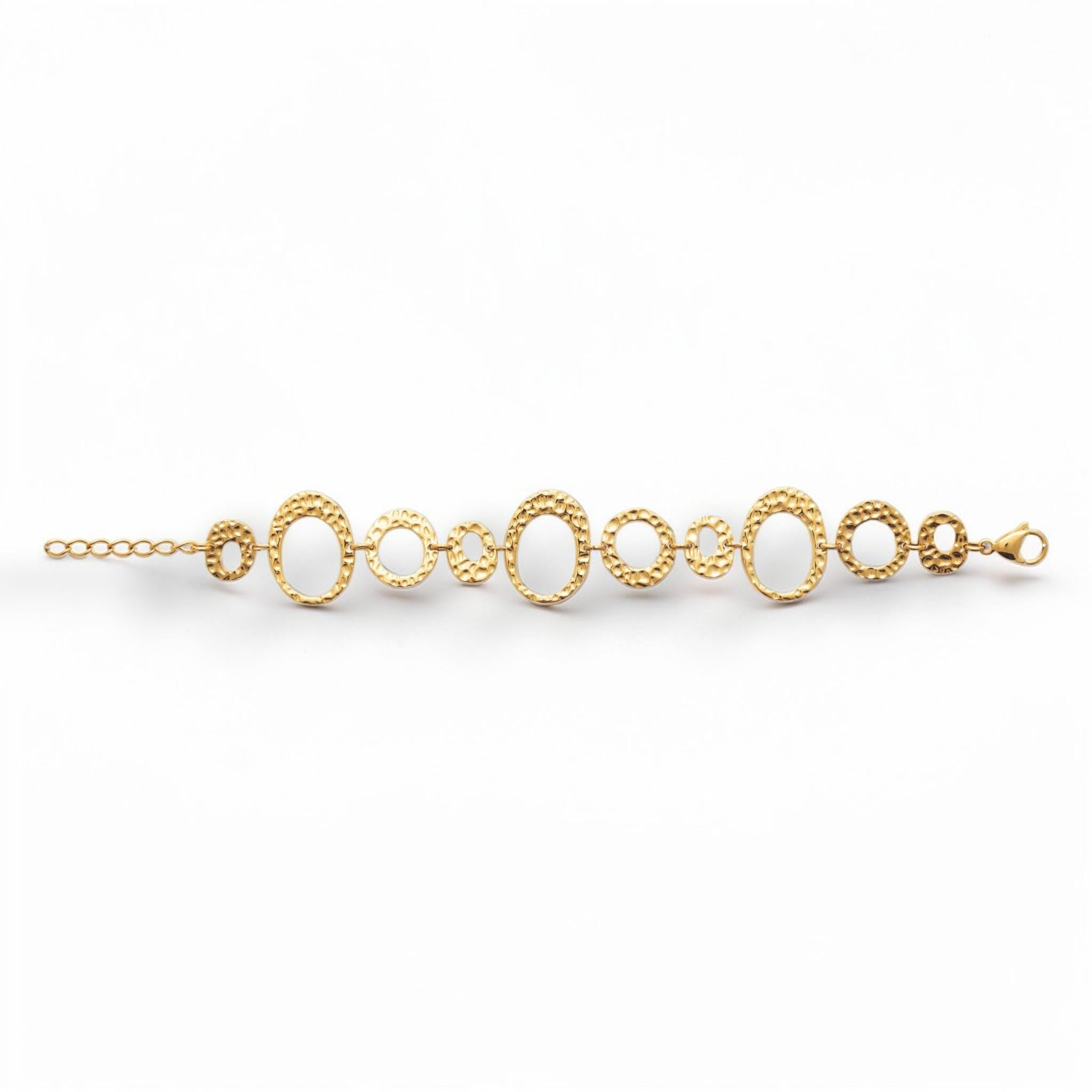 overview of a geometric bracelet opened
Product type: bracelet
Material:  18K Gold Filled, stainless steel base
Color: yellow gold
Style: statement, geometric, elegant, modern
Design details: hammered open circle and oval links, graduated sizes, textured finish, airy openwork design, lobster clasp with extender
Best for: statement styling, special occasions, everyday elevated wear, gifting, artistic jewelry lovers